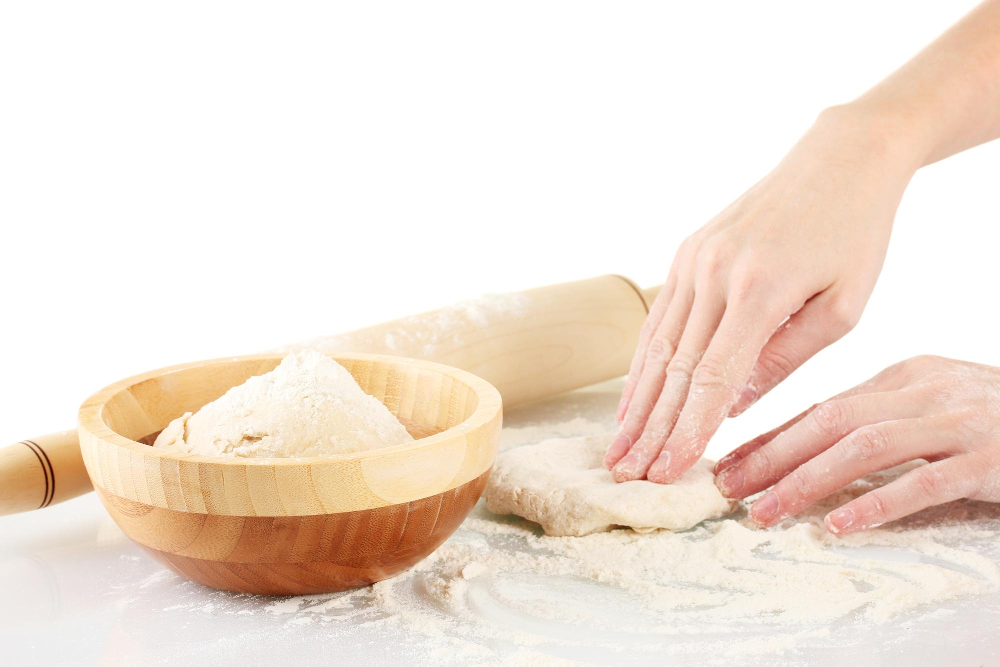 Hands kneading dough in warm kitchen light